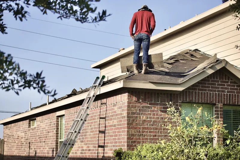 Professional roofer working on a residential roof in Millgate Meadows